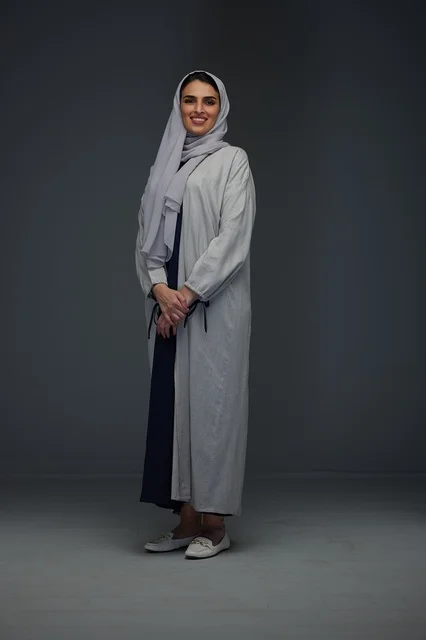 Smiling Saudi Woman in Grey Abaya Standing Studio Portrait