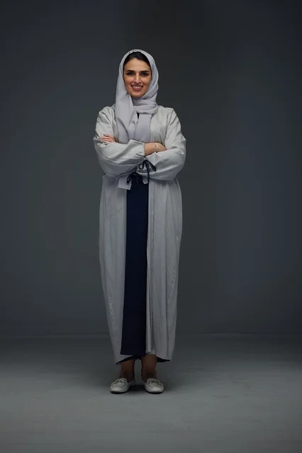Saudi Woman in Grey Abaya Portrait Against Grey Background