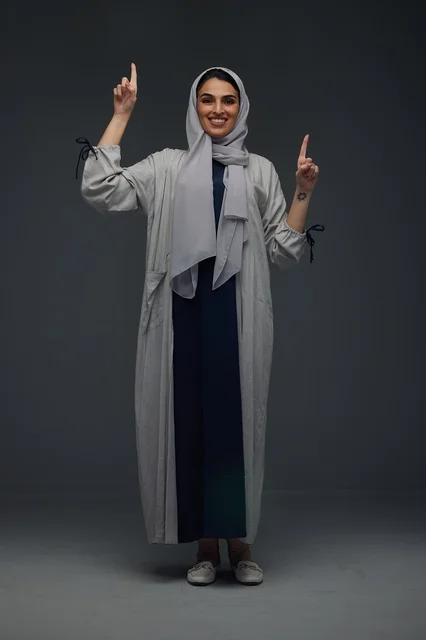 Saudi Woman in Abaya Pointing Up in Studio Portrait