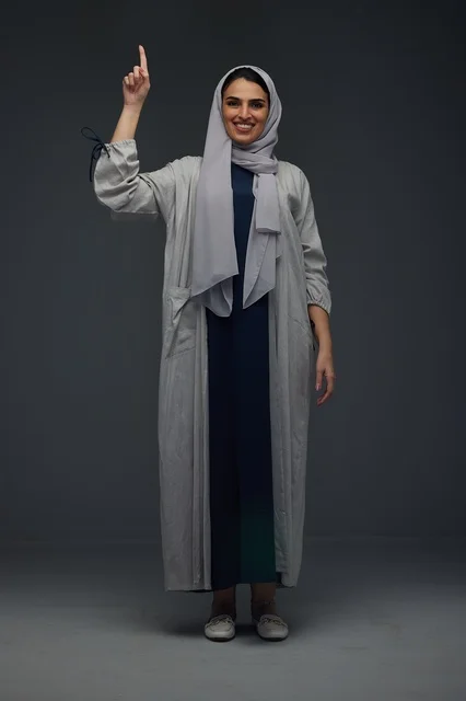 Saudi Woman in Gray Abaya Pointing Up in Studio