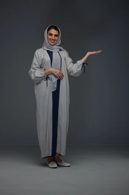Saudi Woman in Abaya Presenting on Grey Background Saudi Woman in Abaya Presenting on Grey Background
