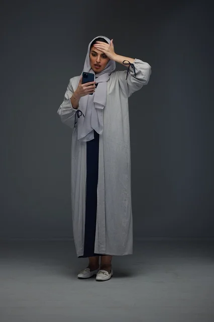 Shocked Saudi Woman Looking at Smartphone in Studio