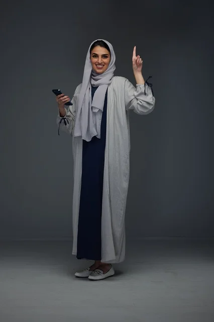 Saudi Woman Holding Smartphone Pointing Upwards