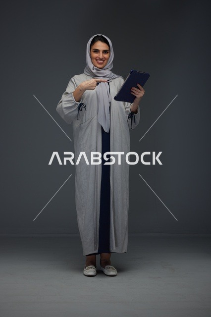 امرأة سعودية تستخدم جهازًا لوحيًا بابتسامة