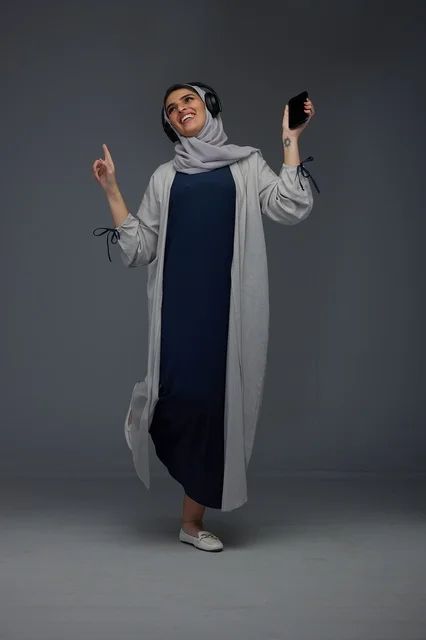 Saudi Woman with Headphones Listening to Music on Phone