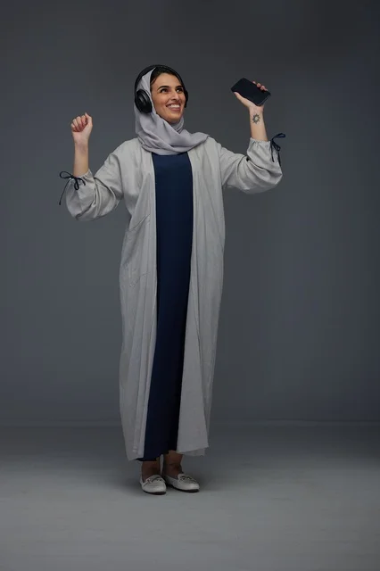 Saudi Woman with Headphones and Smartphone Dancing in Studio