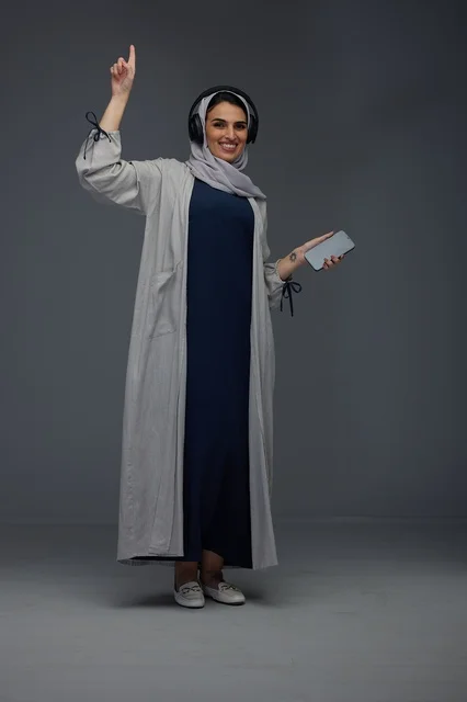 Saudi Woman with Headphones and Smartphone in Studio