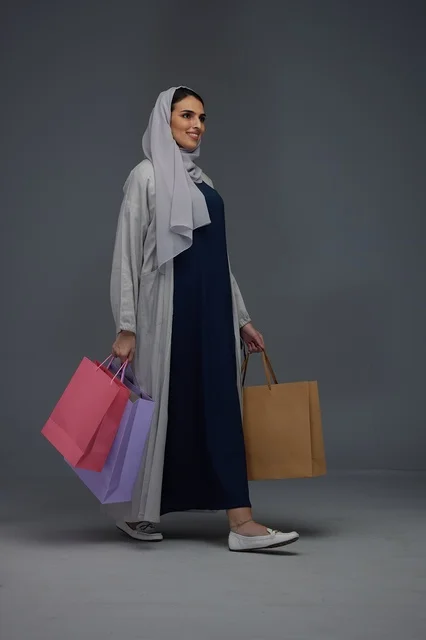 Saudi Woman Carrying Shopping Bags in Grey Abaya Studio