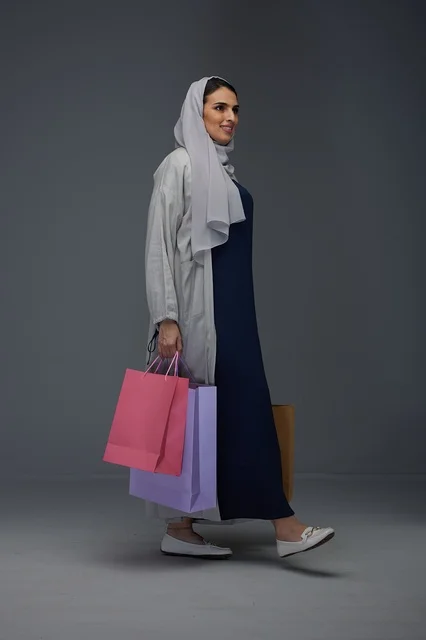 Saudi Woman Carrying Colorful Shopping Bags in Studio