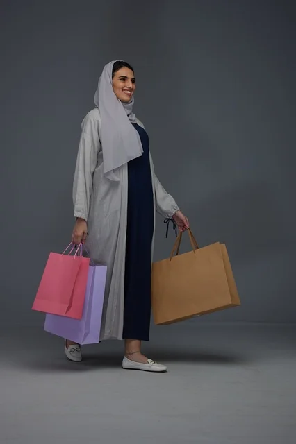 امرأة سعودية تحمل أكياس تسوق في الاستوديو