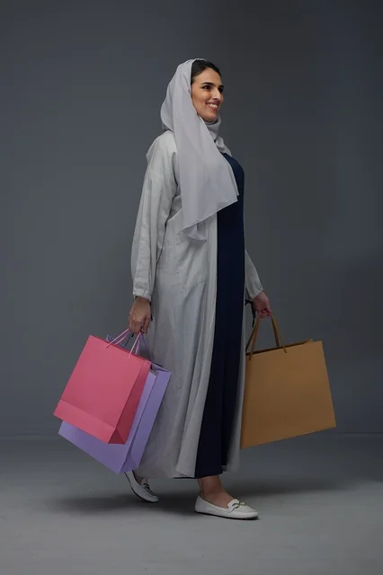 امرأة سعودية تحمل أكياس تسوق في الاستوديو