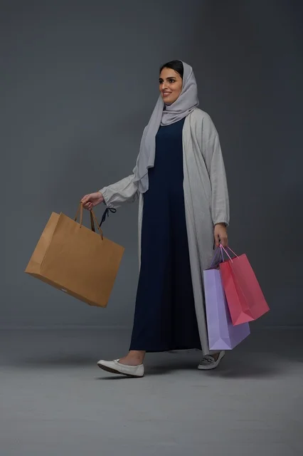 Saudi Woman Carrying Colorful Shopping Bags in Studio