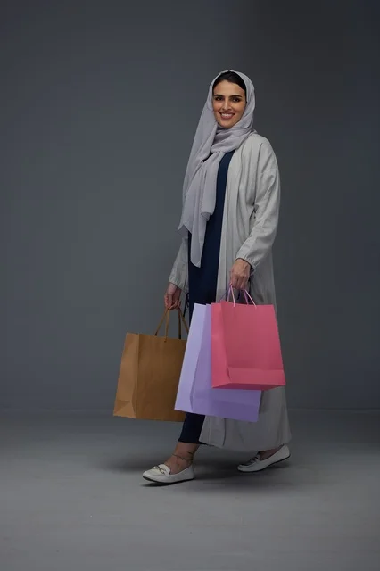 Saudi Woman Carrying Colorful Shopping Bags in Studio