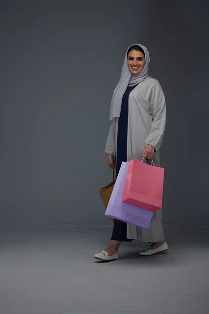 Saudi Woman Walking with Shopping Bags in Grey Studio