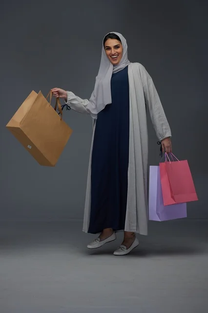 Saudi Woman Holding Shopping Bags in Studio Portrait