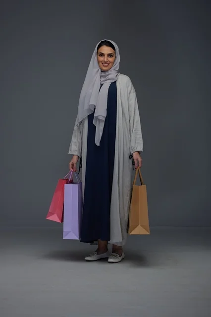 Saudi Woman Holding Shopping Bags in Grey Studio