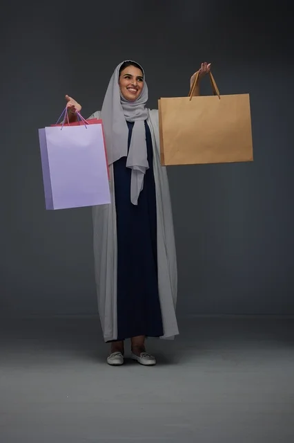 امرأة سعودية بعباية تحمل أكياس تسوق في الاستوديو
