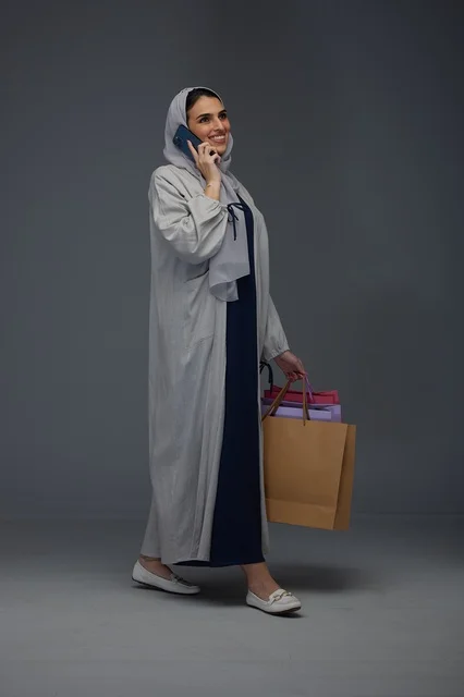 Saudi Woman with Shopping Bags Talking on Smartphone