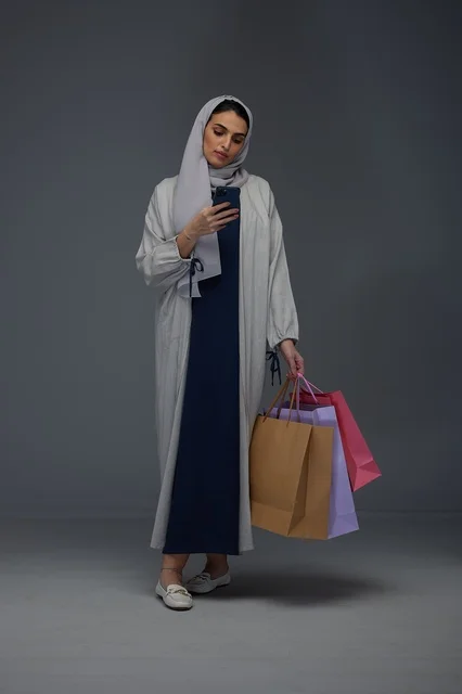 Saudi Woman Shopping with Smartphone in Studio