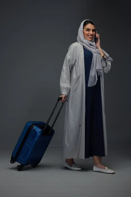 Saudi Woman Traveling with Suitcase and Smartphone