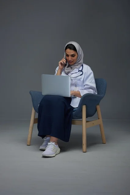 طبيبة سعودية في الاستوديو تستخدم الحاسوب والهاتف