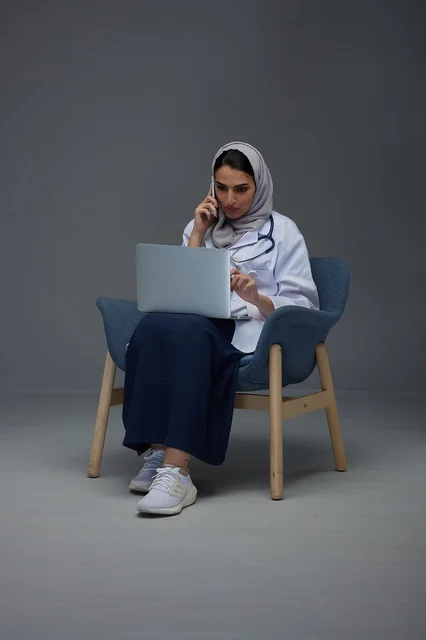 طبيبة سعودية تستخدم الحاسوب المحمول والهاتف الذكي