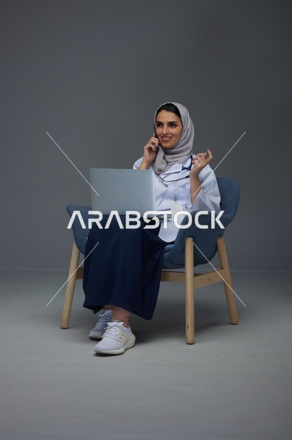 طبيبة سعودية تستخدم الحاسوب المحمول والهاتف في الاستوديو