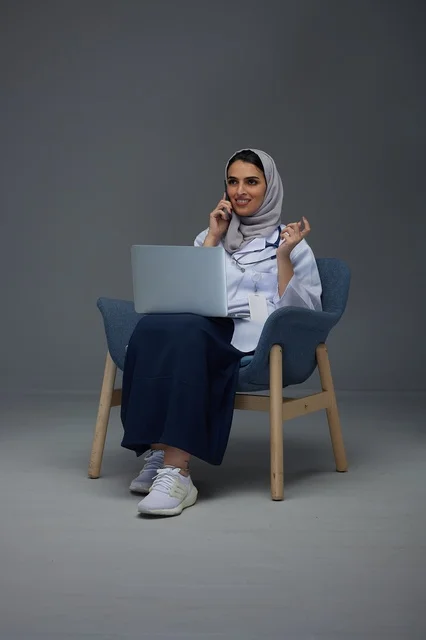 Saudi Female Doctor Using Laptop and Smartphone in Studio