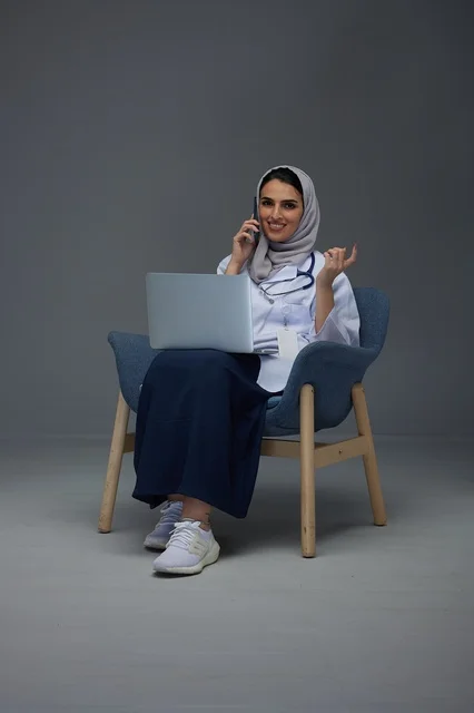 Saudi Female Doctor Using Laptop and Smartphone in Studio