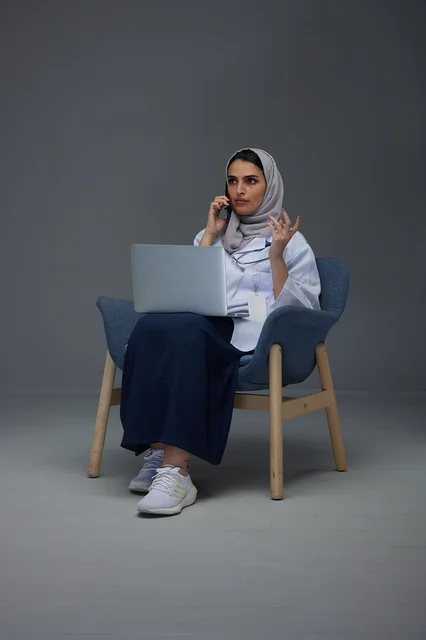 طبيبة سعودية تستخدم الحاسوب المحمول وتتحدث بالهاتف