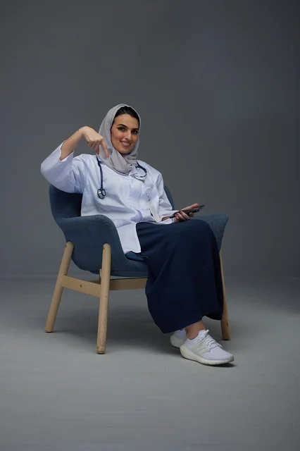 Saudi Female Doctor Pointing Down in Studio Portrait Saudi Female Doctor Pointing Down in Studio Portrait
