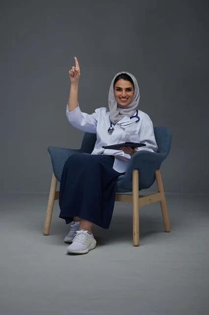 Saudi Female Doctor Pointing Up with Tablet in Studio
