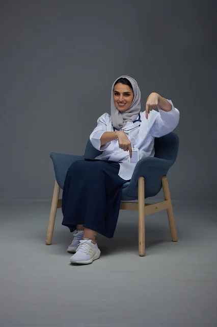 Saudi Female Doctor Pointing Down in Medical Studio