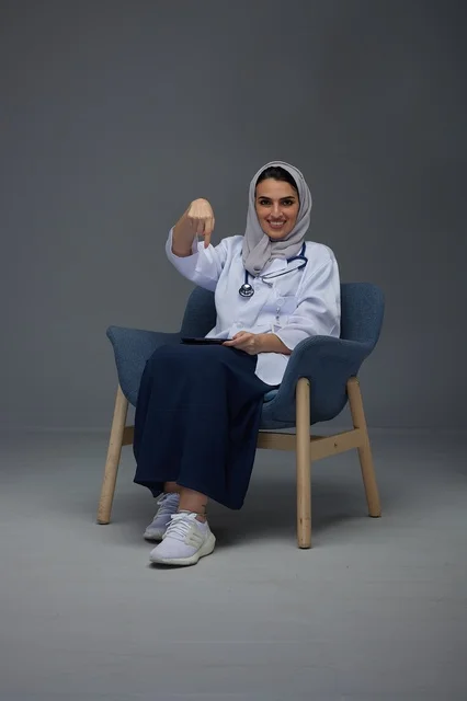 Saudi Female Doctor Pointing Down with Tablet in Studio