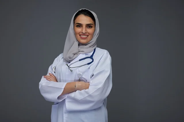 طبيبة سعودية مبتسمة بالمعطف الطبي الأبيض