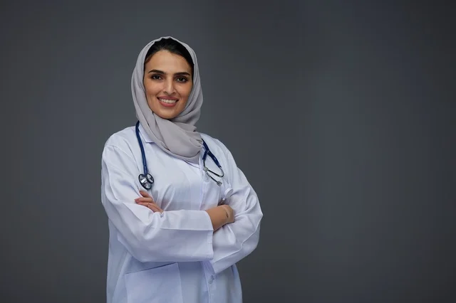 طبيبة سعودية مبتسمة بالمعطف الطبي الأبيض