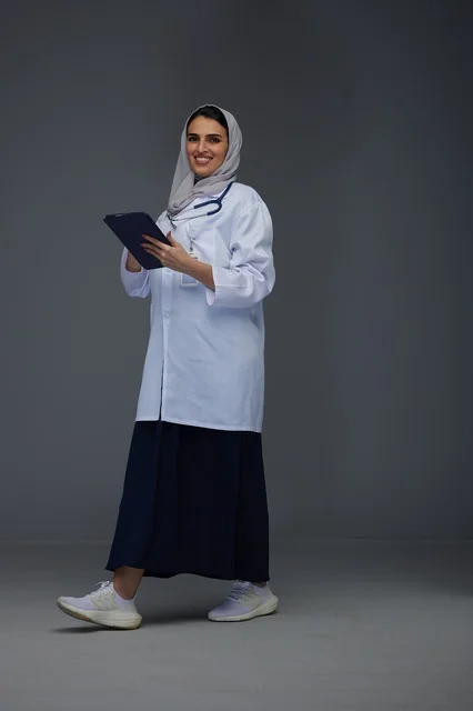 Saudi Female Doctor Using Tablet in Medical Uniform