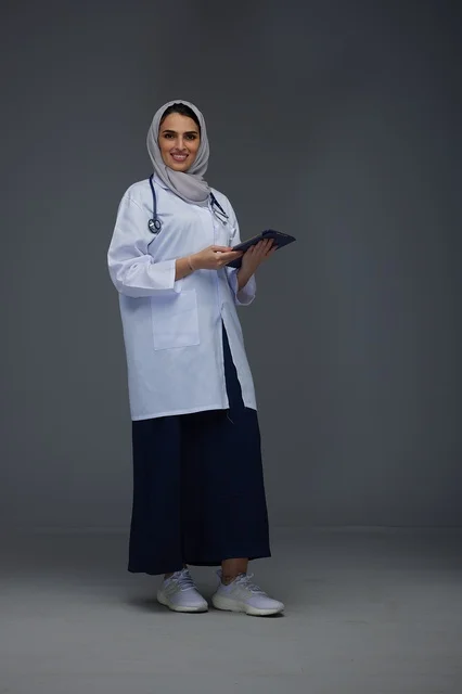 طبيبة سعودية تستخدم جهازاً لوحياً بالزي الطبي