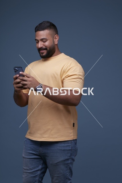 رجل سعودي يستخدم الهاتف الذكي بخلفية زرقاء