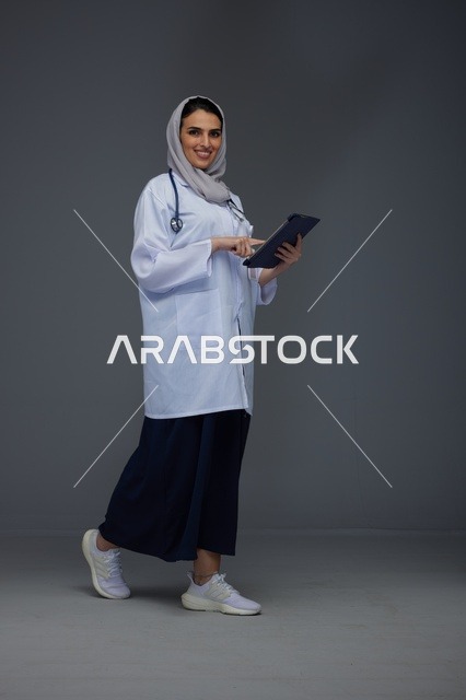 طبيبة سعودية تستخدم جهاز لوحي بالزي الطبي