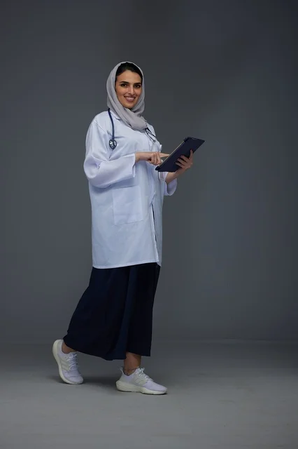 Saudi Female Doctor Using Tablet in Medical Uniform