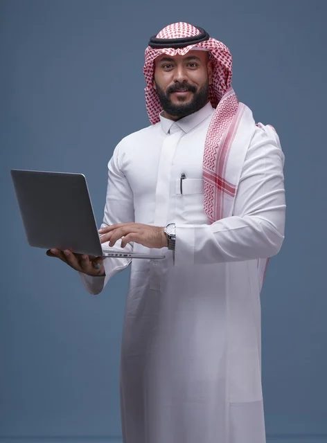 Saudi Man in Traditional Thobe Using Laptop
