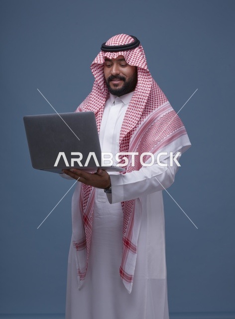 Saudi Man Using Laptop in Traditional Arabic Attire