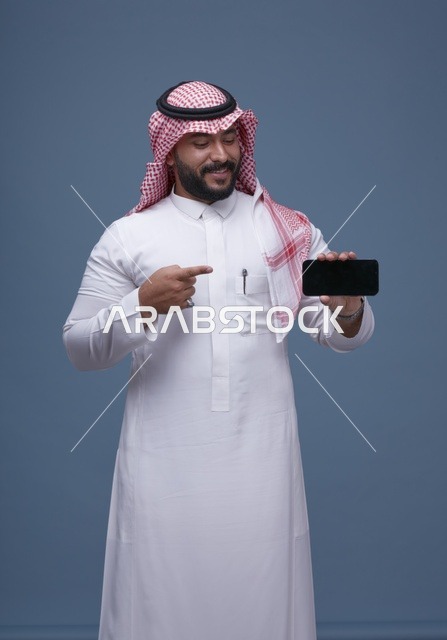 رجل سعودي يحمل هاتف ذكي بشاشة فارغة