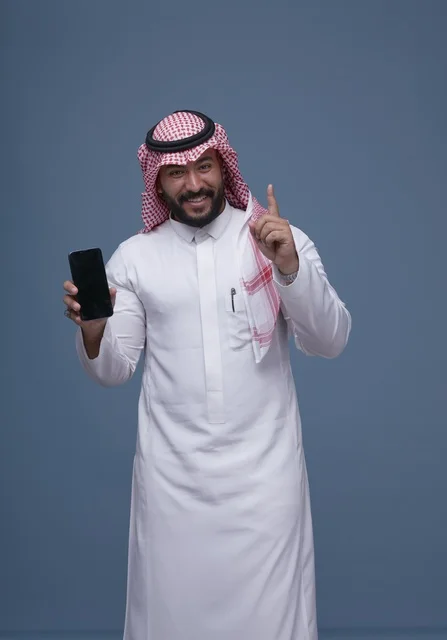Saudi Man in Traditional Dress Holding Blank Smartphone