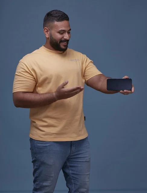 Saudi Man Holding Blank Smartphone Screen on Blue Background