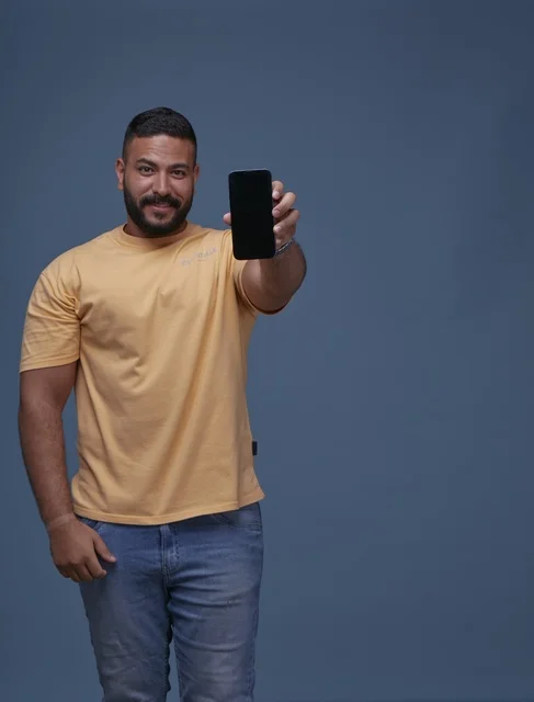Saudi Man Holding Blank Smartphone Screen in Casual Wear