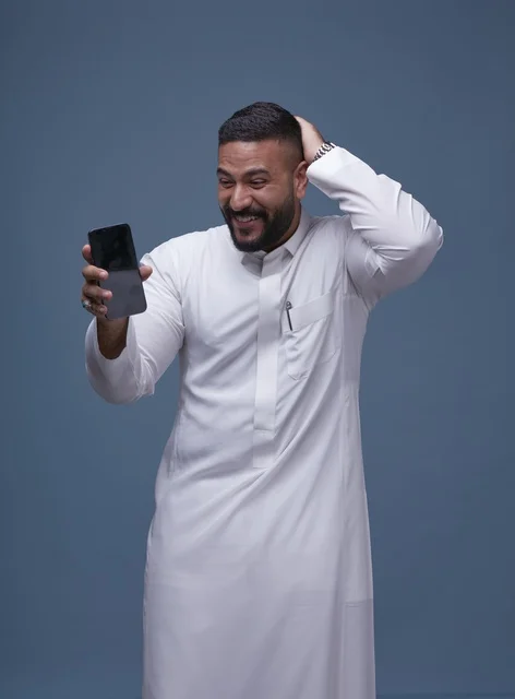 Saudi Man in White Thobe Surprised by Smartphone Screen