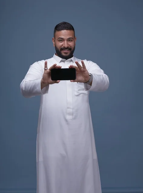 Saudi Man Holding Blank Smartphone Screen in White Thobe