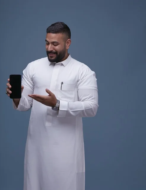 Saudi Man in White Thobe Holding Blank Smartphone